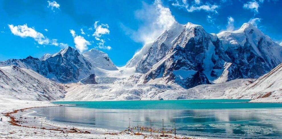 Pristine Gurudongmar Lake surrounded by snow mountains North Sikkim